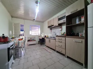 Foto interna de uma cozinha com armários e piso de cerâmica.