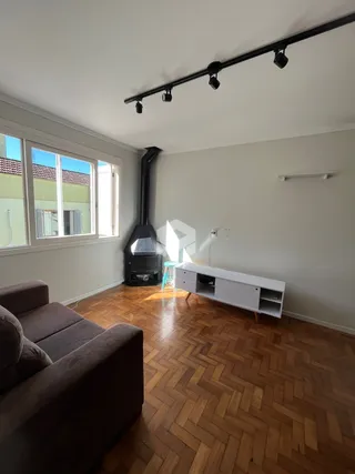 Sala de estar com piso de madeira e janela.