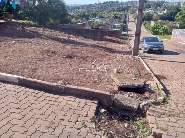 Vista externa de uma propriedade com terreno inclinado e calçada.
