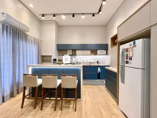 Cozinha moderna com armários azuis e bancada de ilha em um ambiente claro.