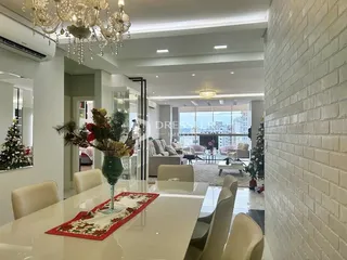 Ambiente interno de uma sala com mesa de jantar e parede de tijolos
