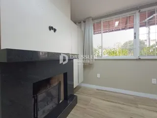 Foto de uma sala de estar com lareira e grande janela.