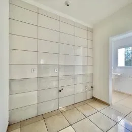 Parede revestida com azulejos brancos em um ambiente interno.