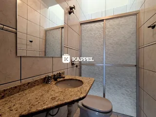 Banheiro com bancada de granito e vaso sanitário em um imóvel.