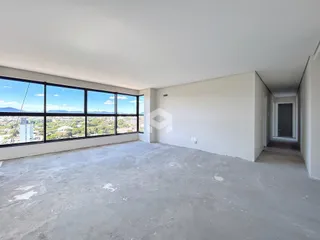 Vista de uma sala ampla com grande janela de vidro em um imóvel em Lajeado.