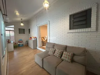 Sala de estar com sofá e piso de madeira clara.