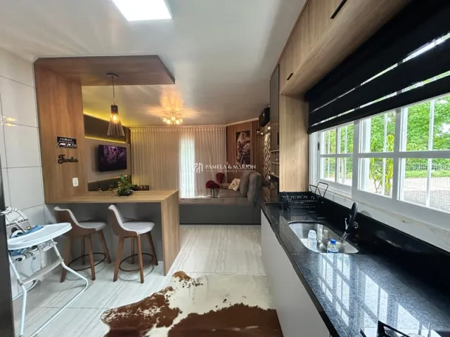 Sala de estar com sofá e painéis de madeira em um imóvel no Brasil.