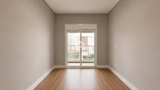Vista interna de um ambiente com piso de madeira clara e paredes neutras.