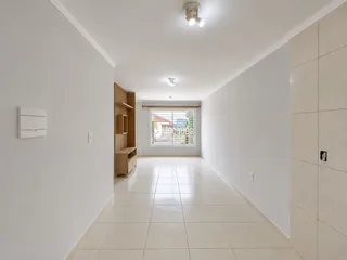 Corredor interno com piso de cerâmica e paredes brancas.