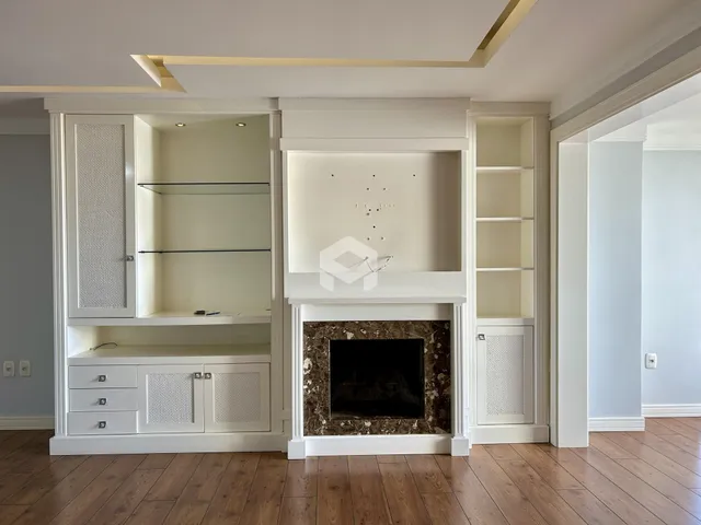Esta é uma sala de estar com armários embutidos e lareira.