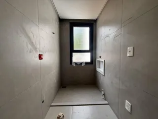 Vista de um corredor interno com paredes lisas e piso de concreto.