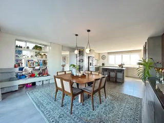 Sala de jantar com mesa de madeira e ambiente integrado em Lajeado.