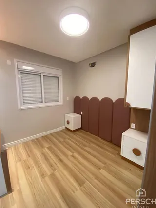 Foto de um cômodo interno com piso de madeira clara e janela.