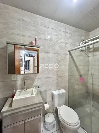 Foto de um banheiro com revestimento de azulejos brancos e box de vidro.