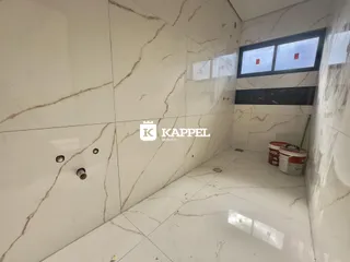 Vista interna de um ambiente com revestimento de mármore branco.