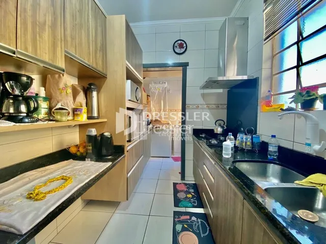 Foto de uma cozinha com armários de madeira e bancadas escuras.