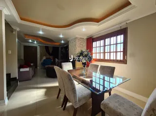 Sala de estar com piso claro e janelas grandes em um imóvel no Brasil.