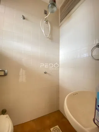 Foto de um banheiro com revestimento branco e piso de madeira.