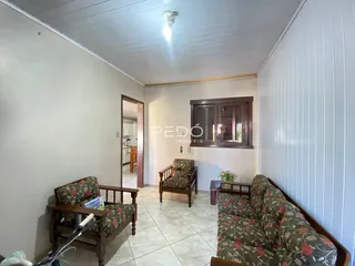 Sala de estar com móveis de madeira e paredes brancas.