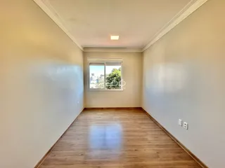 Vista interna de uma sala de estar com piso de madeira clara.
