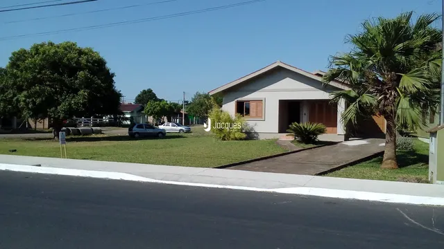 Fachada de uma casa em Lajeado, Brasil, com gramado e vegetação ao redor.