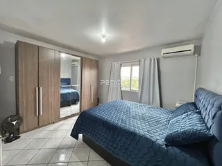 Quarto com armários em madeira e cama azul.