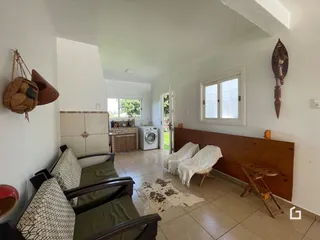 Sala de estar com piso de cerâmica e móveis de madeira clara.