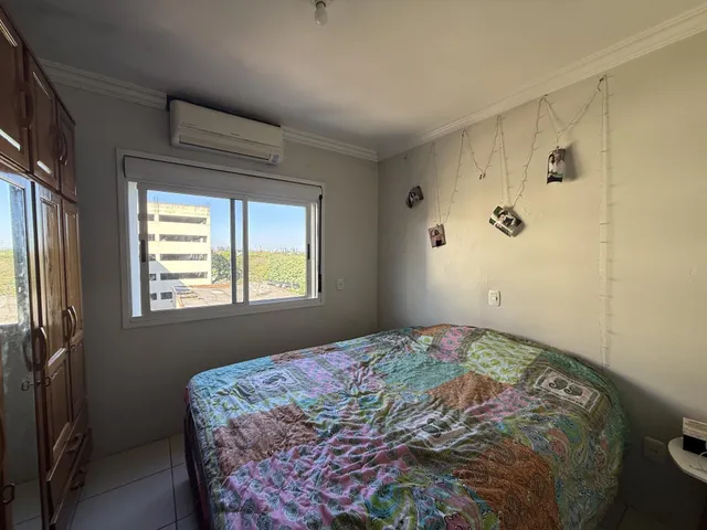 Quarto com cama grande e janela de vista para a cidade.