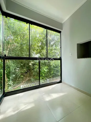 Vista interna de uma sala com grande janela de vidro em Lajeado.