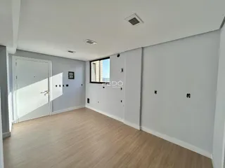 Sala de estar com piso de madeira clara e paredes cinzas.