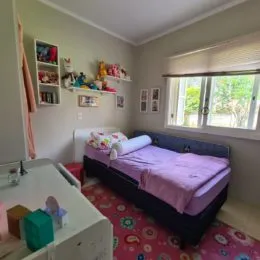 Quarto com cama e quadros decorativos na parede.