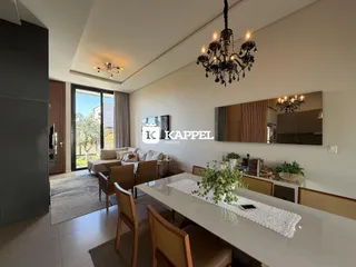 Sala de estar com sofá e mesa de jantar em um apartamento em Lajeado.