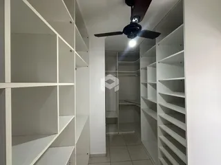 Corredor interno com estantes brancas.