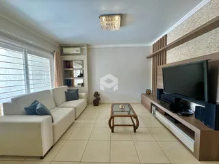 Sala de estar com sofá branco e painel de madeira na decoração.