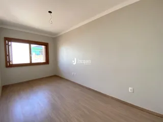 Sala de estar com piso de madeira clara e janela.