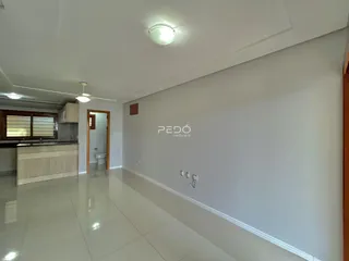 Ambiente interno de uma sala com piso de cerâmica e paredes brancas.