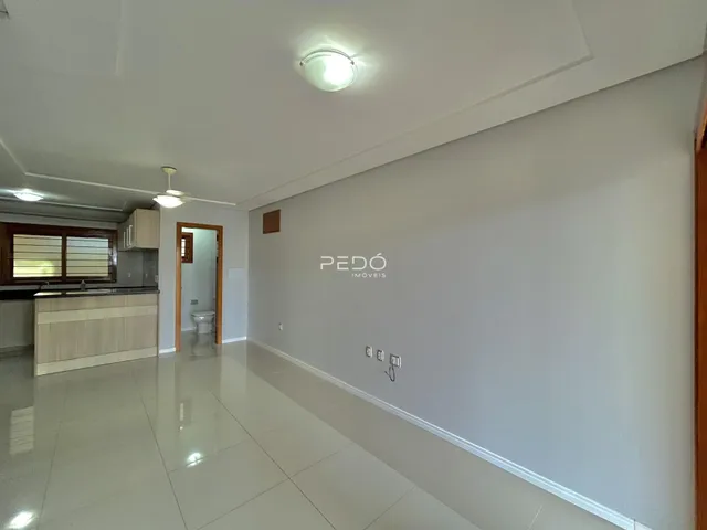 Ambiente interno de uma sala com piso de cerâmica e paredes brancas.