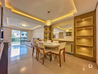 Ambiente de sala de estar e jantar com piso claro e móveis modernos.