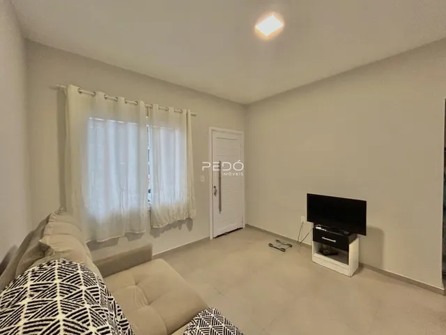 Sala de estar com sofá e janela iluminada.