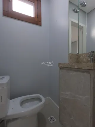 Foto de um banheiro com louças sanitárias brancas e bancada de mármore.