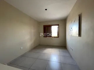 Ambiente interno de uma sala com piso de cerâmica clara.