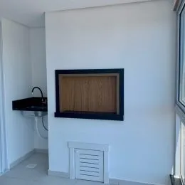 Parede branca com um quadro escuro em um ambiente interno.