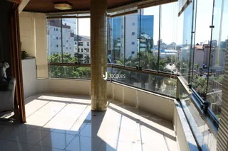 Vista de um ambiente interno com acesso a uma varanda com vista para a cidade.