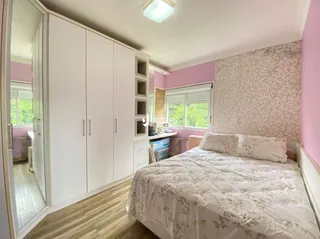 Quarto com armários embutidos e cama em um imóvel.