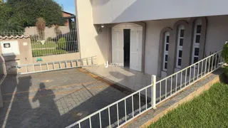 Fachada de uma residência em Lajeado, Brasil, com portão e muro branco.