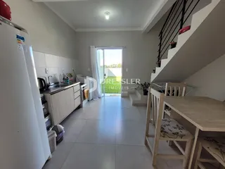 Imagem de uma sala de estar com cozinha em um apartamento.