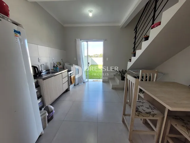 Imagem de uma sala de estar com cozinha em um apartamento.
