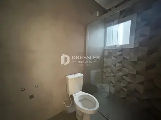Foto de um banheiro com azulejos e box de vidro.