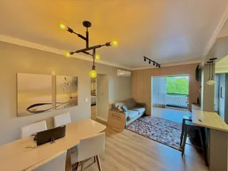 Sala de estar com sofá e mesa de jantar em um apartamento.
