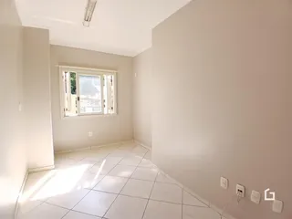 Interior de uma sala com piso de cerâmica e paredes brancas.
